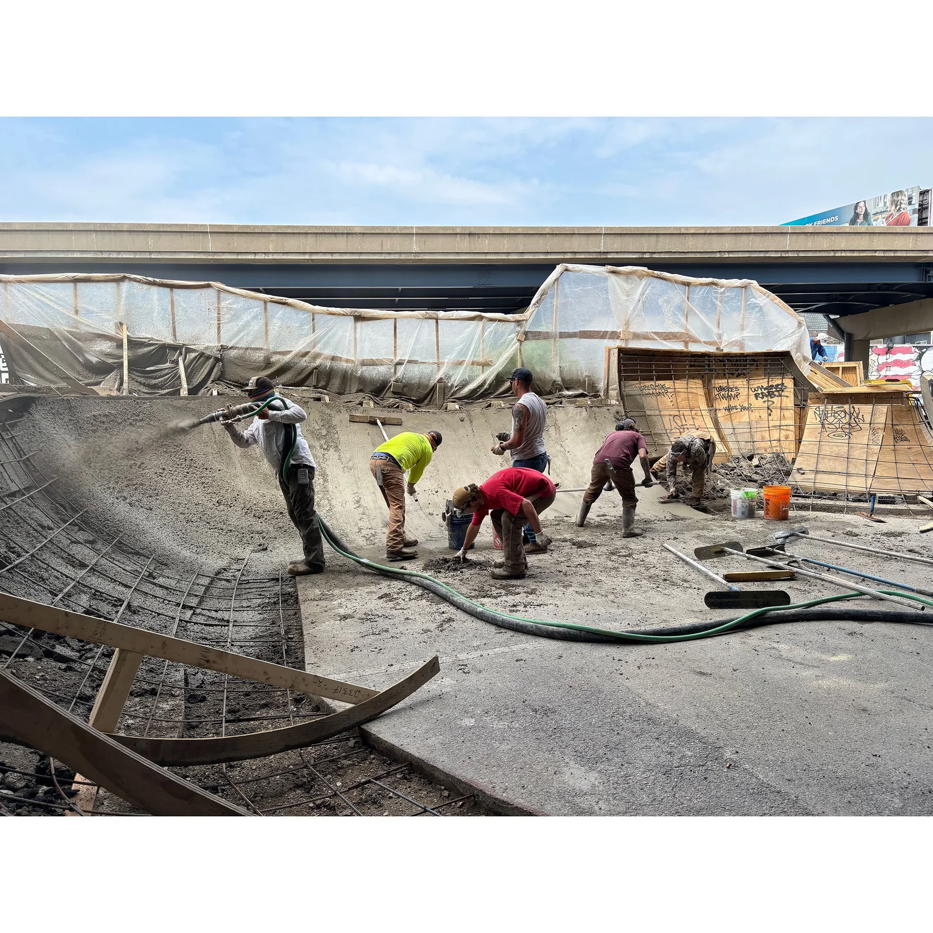 Wide photo shot showing a team of community members constructing a skateboarding obstacle.